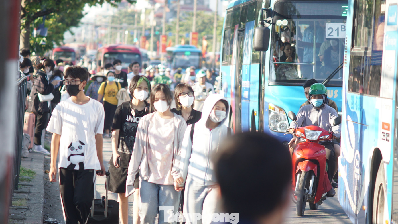 Tại khu vực bến xe Giáp Bát, nhiều người dân đi bộ phải tràn xuống lòng đường để di chuyển khiến các phương tiện phải đi chậm.