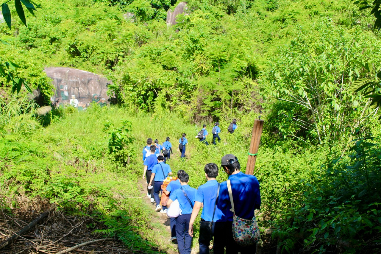 Các bạn trẻ phải hành quân một đoạn đường băng núi, leo qua những tảng đá cao để tiếp cận nơi các chiến sĩ đã từng làm việc.