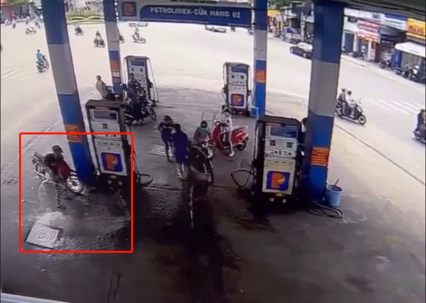 Người đàn ông tưới chất gây cháy vào một trụ xăng ở khu vực Mã Vòng, TP Nha Trang. (Ảnh cắt từ clip).