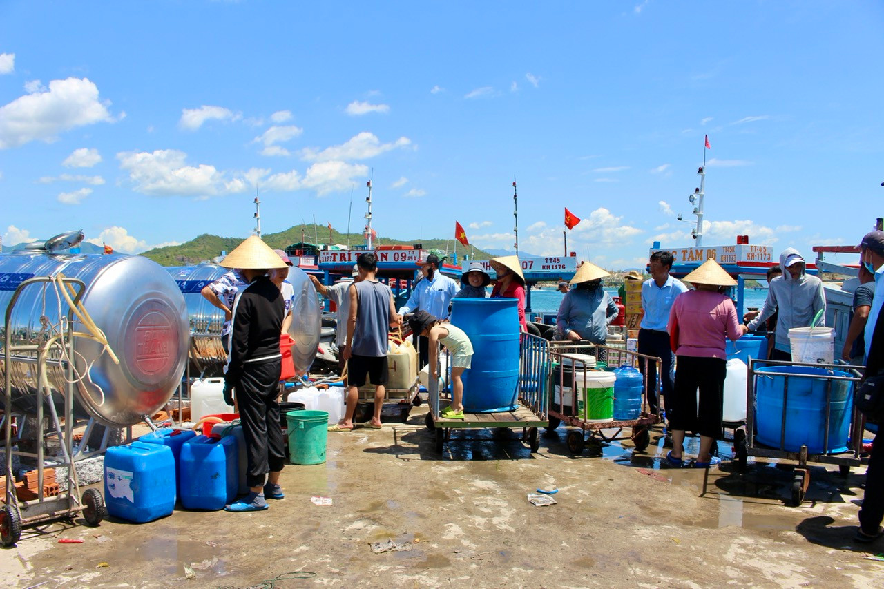 Hàng nghìn người dân trên đảo Trí Nguyên “đội nắng” xếp hàng chờ hứng nước sạch về sử dụng trong thời gian bị ngừng cấp nước.