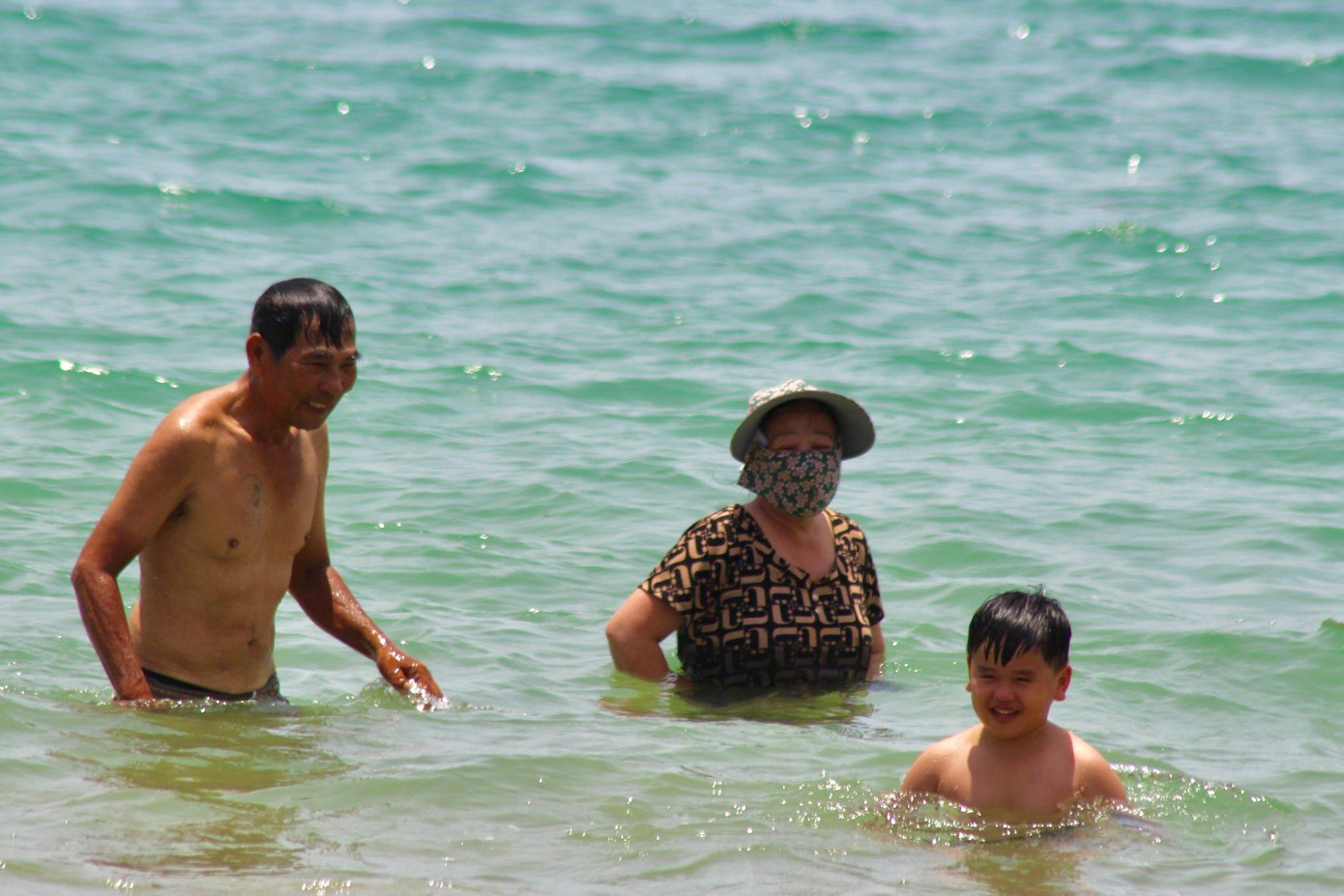 Một số người đội mũ, trùm kín mặt khi tắm biển.