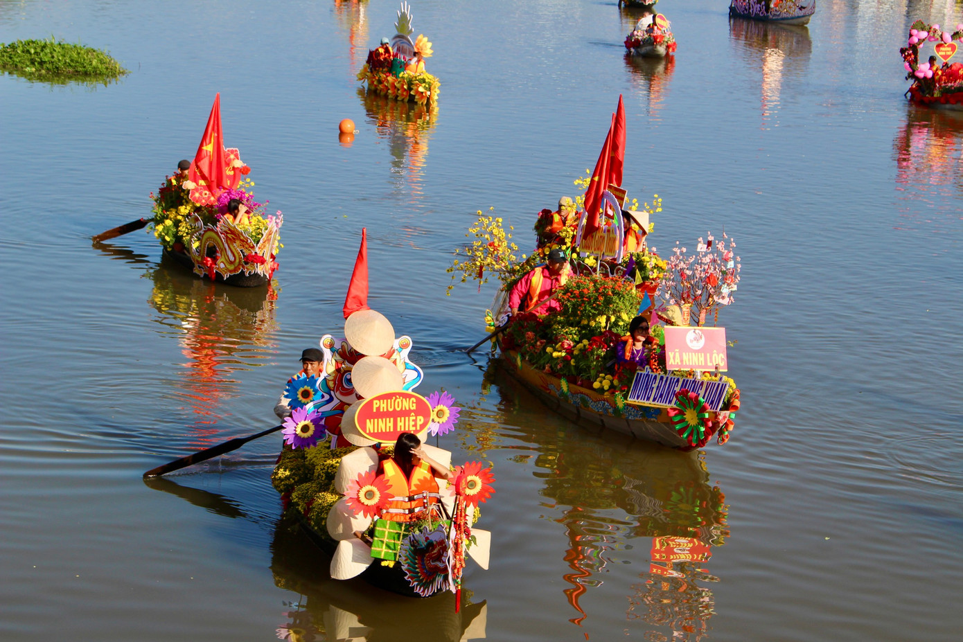 28 chiếc thuyền hoa được trang trí hoa tươi đẹp mắt mang nét đặc trưng của từng xã, phường. Những chiếc thuyền xuôi theo dòng sông Dinh trình diễn để ban giám khảo chấm điểm.