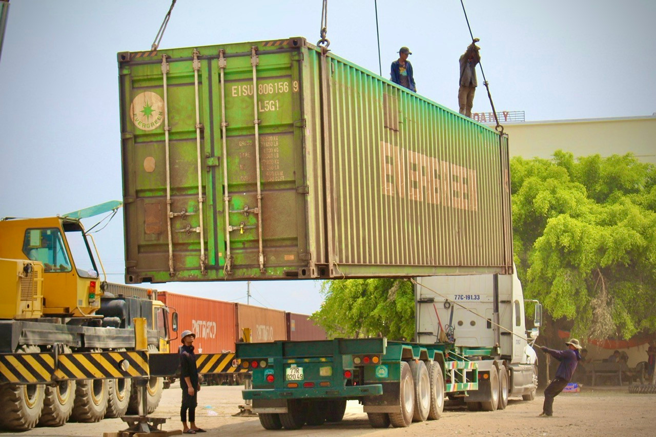 Khi hàng được cẩu từ tàu hỏa sang xe tải, cần có sự phối hợp ăn ý của các công nhân để cố định thùng hàng lên đến hàng chục tấn xuống đúng vị trí.