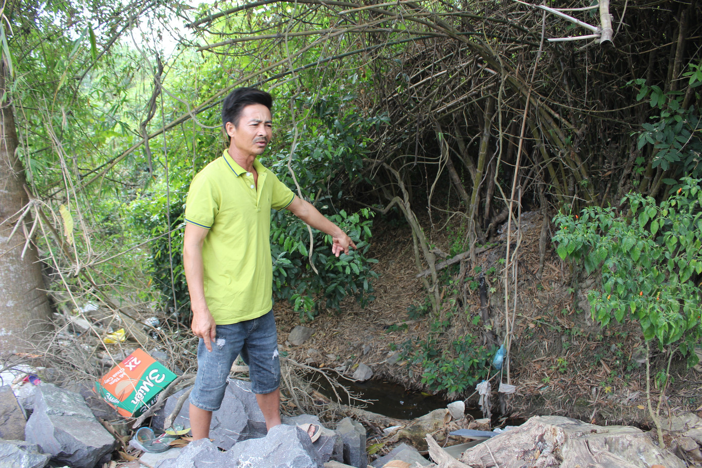 Ông Võ Ngọc Tân (ở xã Diên Lâm) bức xúc chỉ vào nguồn nước quanh nhà cũng bị ảnh hưởng đen kịt.