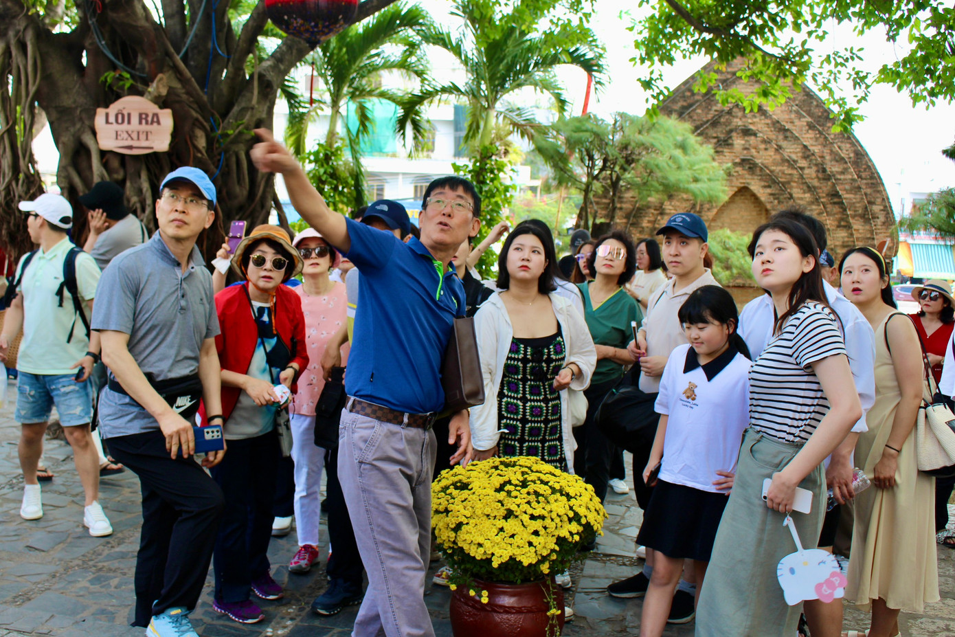 Nhóm du khách đến từ Hàn Quốc chăm chú lắng nghe hướng dẫn viên giới thiệu về kiến trúc của Tháp Bà Ponagar.