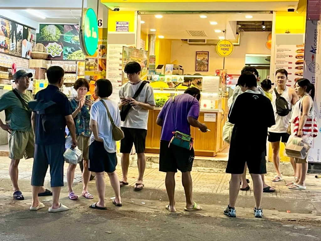 Khách nước ngoài xếp hàng chờ mua bánh mì ở TP Nha Trang.