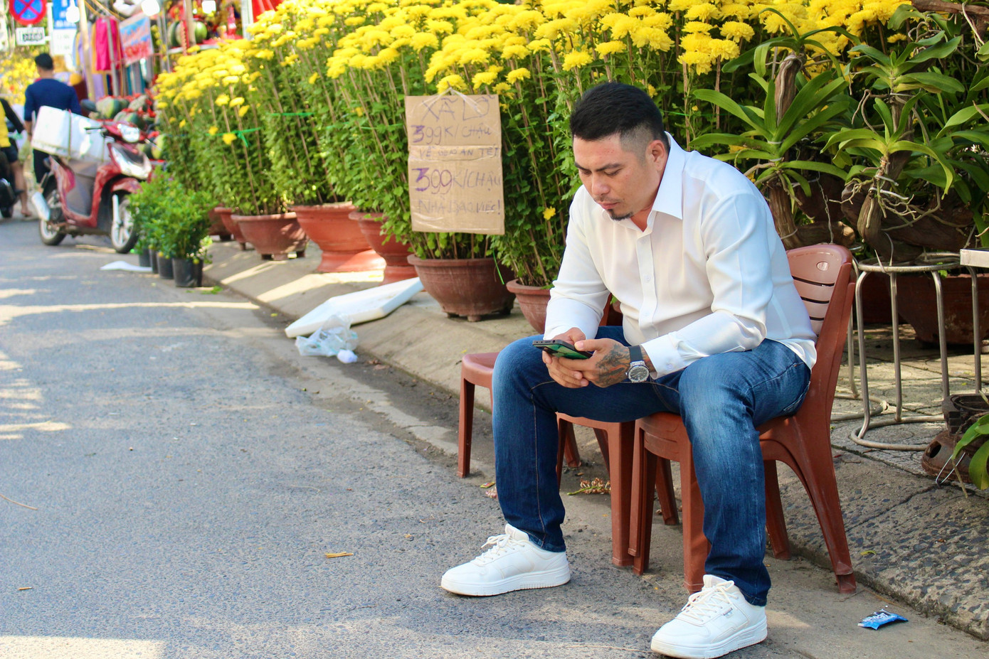 Tiểu thương bấm điện thoại “ngóng” khách đến.