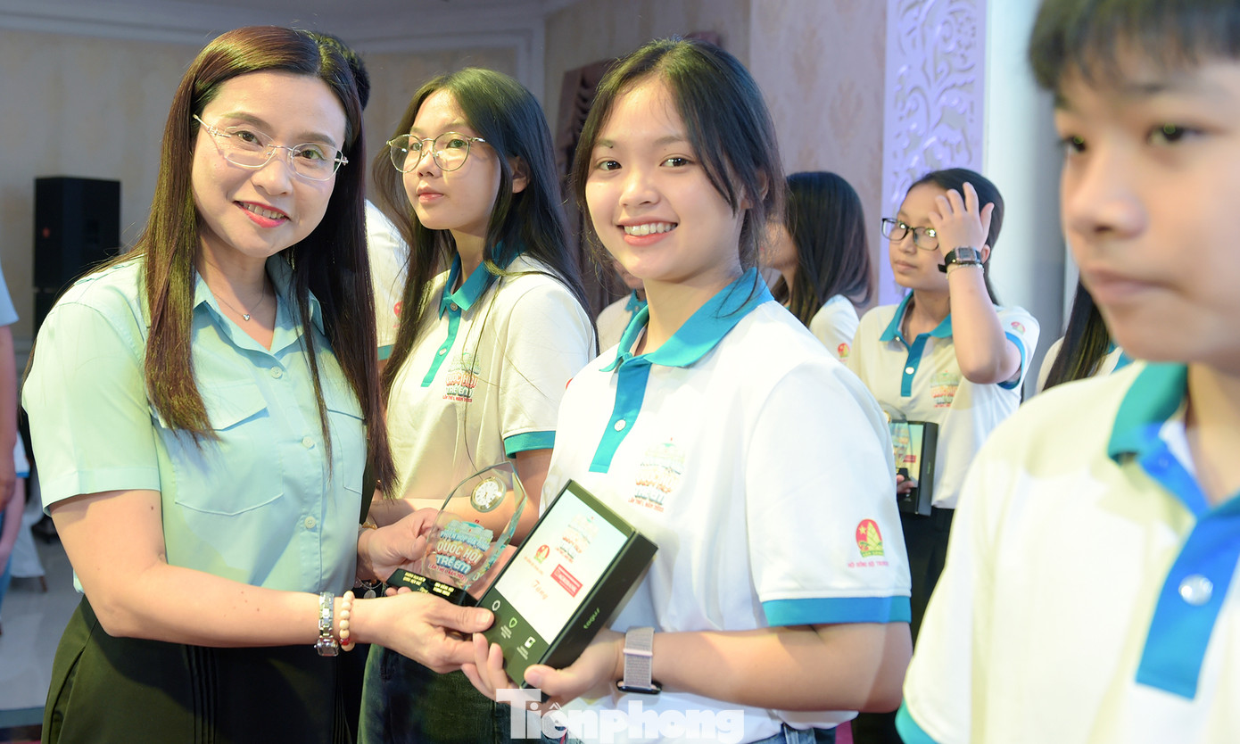 Chị Nguyễn Phạm Duy Trang trao quà tặng đại biểu thiếu nhi tham dự Phiên họp. Ảnh: Xuân Tùng