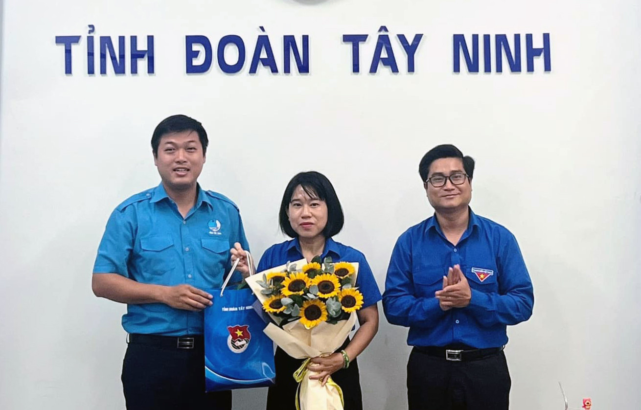 Anh Nguyễn Thanh Tùng và anh Trần Đăng Tiến tặng hoa, quà lưu niệm cho chị Nguyễn Thị Trúc Mai - Phó Bí thư thường trực Tỉnh Đoàn Tây Ninh, được phân công nhiệm vụ mới và thôi làm Chủ tịch Hội LHTN Việt Nam tỉnh Tây Ninh. Ảnh: TĐTN