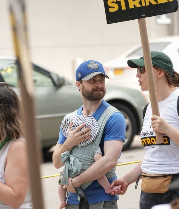 Daniel Radcliffe bế con trên đường. Daniel Radcliffe bế con trên đường.