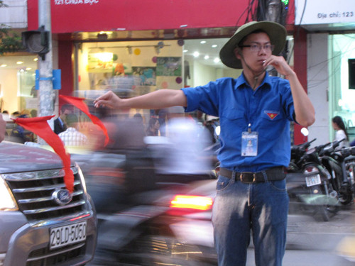 Để hoạt động nhịp nhàng, cả đội phải tuân thủ hiệu lệnh của đội trưởng. Trong ảnh là Hải Long, đội tưởng đội điều tiết giao thông chiều 4 - 10. Ảnh: Lãng Phong