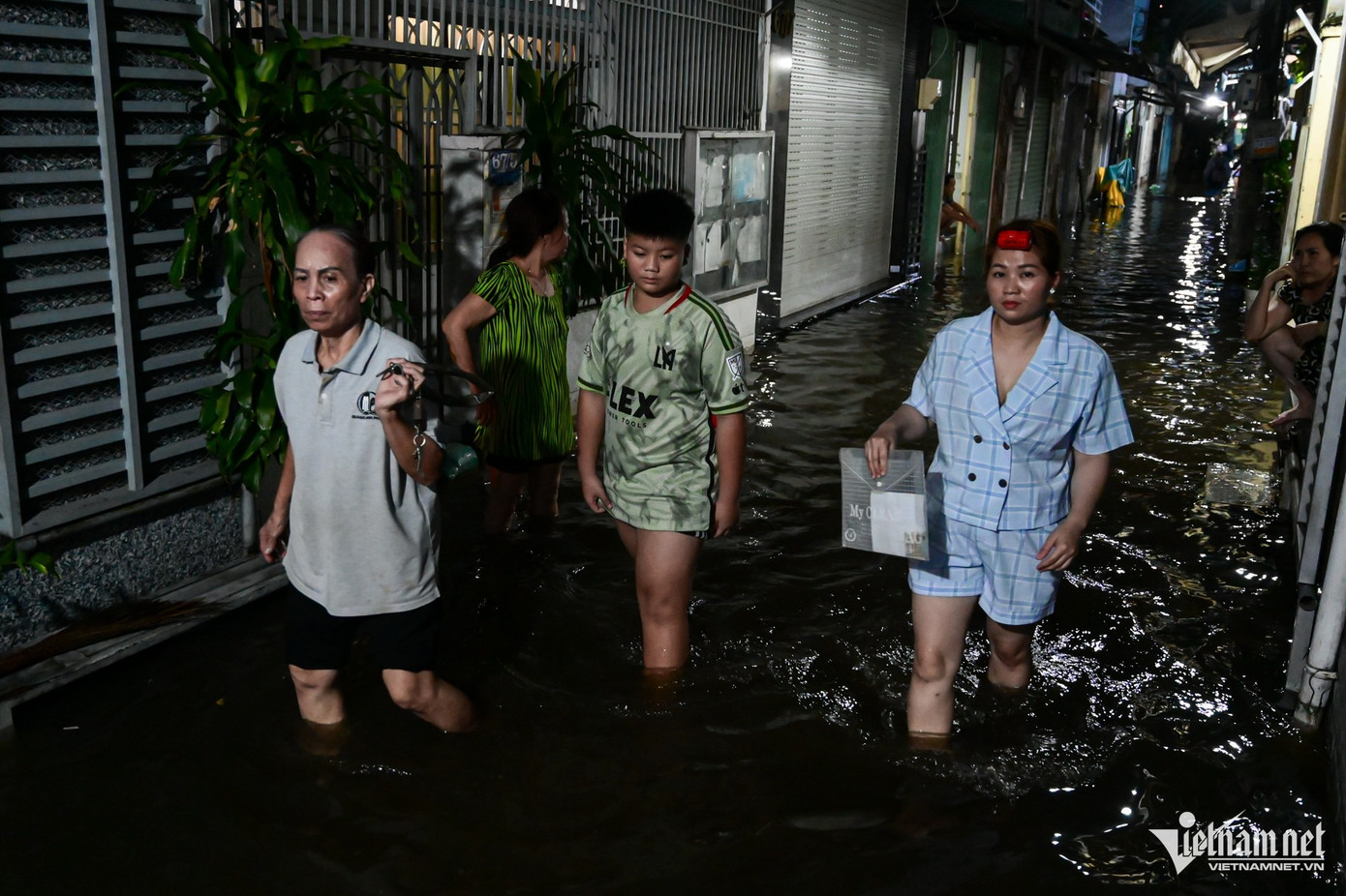 Gần nửa đêm, người dân vẫn bì bõm lội nước về nhà. Gần nửa đêm, người dân vẫn bì bõm lội nước về nhà.