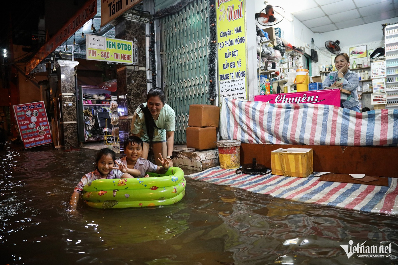 Tối 18/10, chị Hồng Phương (đường Phú Thuận, quận 7) cùng các con chơi trên nước ngập khi các bé đã quen với cảnh này. Tình trạng triều cường dâng vào dịp rằm tháng 9 lần này cao hơn so với rằm tháng trước, công việc buôn bán của chị Phương vì vậy bị ảnh hưởng. Nhưng thay vào đó, chị lại có thêm thời gian dành cho con. Tối 18/10, chị Hồng Phương (đường Phú Thuận, quận 7) cùng các con chơi trên nước ngập khi các bé đã quen với cảnh này. Tình trạng triều cường dâng vào dịp rằm tháng 9 lần này cao hơn so với rằm tháng trước, công việc buôn bán của chị Phương vì vậy bị ảnh hưởng. Nhưng thay vào đó, chị lại có thêm thời gian dành cho con.