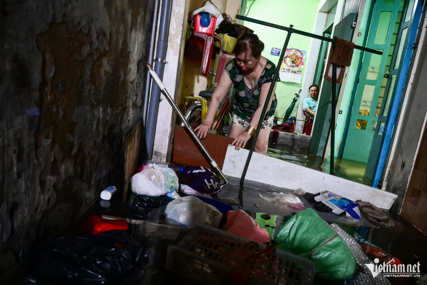 Nước dâng cao mang theo nhiều rác thải trôi dạt, bít kín lối đi trước cửa nhà bà Nguyễn Thị Dững (60 tuổi). Bà phải đi ủng cả ngày trong chính ngôi nhà của mình. Nước dâng cao mang theo nhiều rác thải trôi dạt, bít kín lối đi trước cửa nhà bà Nguyễn Thị Dững (60 tuổi). Bà phải đi ủng cả ngày trong chính ngôi nhà của mình.