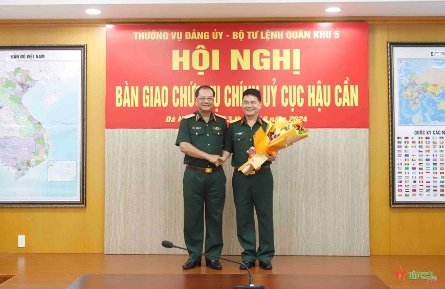 Thiếu tướng Cao Phi Hùng, Phó tư lệnh Quân khu 5, tặng hoa chúc mừng Đại tá Bùi Tá Tuân tại hội nghị. Ảnh: QĐND.