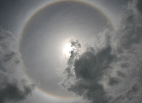 Năm ngoái, Lào Cai từng ghi nhận hiện tượng này. Quầng mặt trời là hiện tượng quang học, do ánh sáng của mặt trời hay mặt trăng chiếu qua đám mây tầng cao (độ cao khoảng 7-8 km). Mây có cấu trúc là các tinh thể băng, ánh sáng mặt trời, mặt trăng bị khúc xạ, phản xạ sinh ra những vòng tròn. Ảnh: Báo Lào Cai