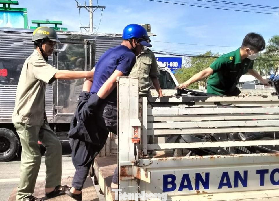 Đối tượng bị đưa lên xe công vụ di chuyển về trụ sở công an để làm rõ