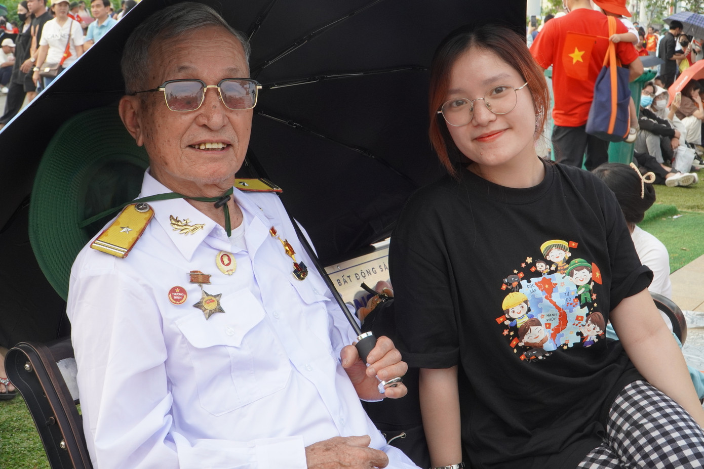 Một bạn trẻ chụp hình cùng một cựu chiến binh tại công viên.