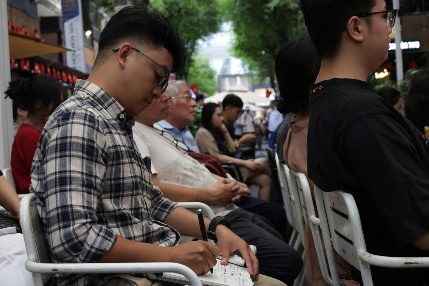 Một bạn trẻ chăm chú ghi chép lại lời chia sẻ của các khách mời.