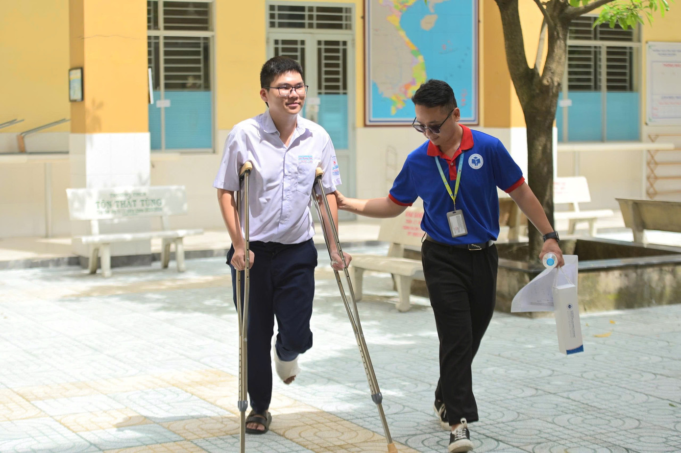 Gia Phát được bạn tình nguyện viên hỗ trợ ở điểm thi. (Ảnh: Đông Hải)