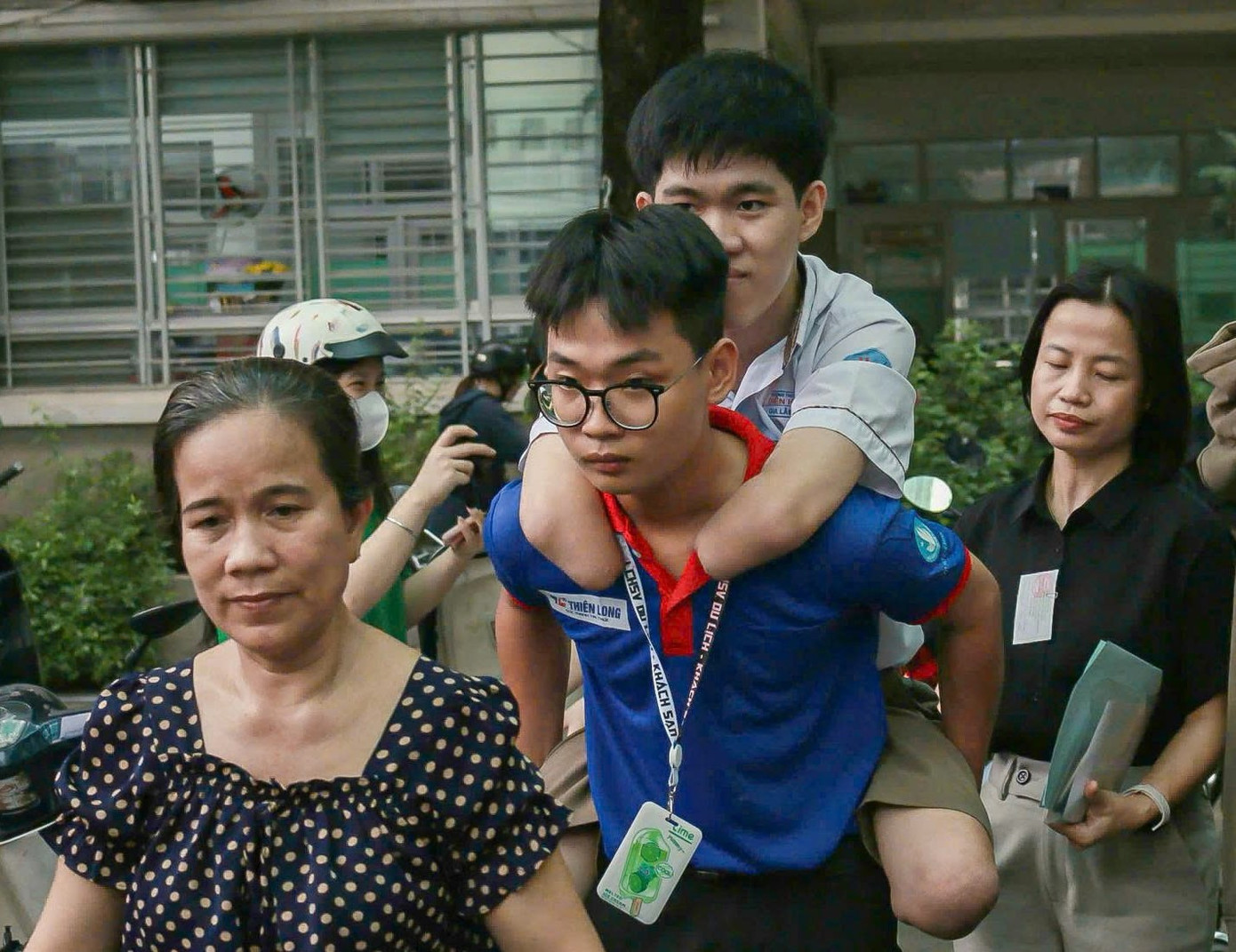 Khoảnh khắc xúc động tình nguyện viên cõng thí sinh đến làm thủ tục thi tốt nghiệp THPT 2025. (Ảnh: HUFLIT) Khoảnh khắc xúc động tình nguyện viên cõng thí sinh đến làm thủ tục thi tốt nghiệp THPT 2025. (Ảnh: HUFLIT)