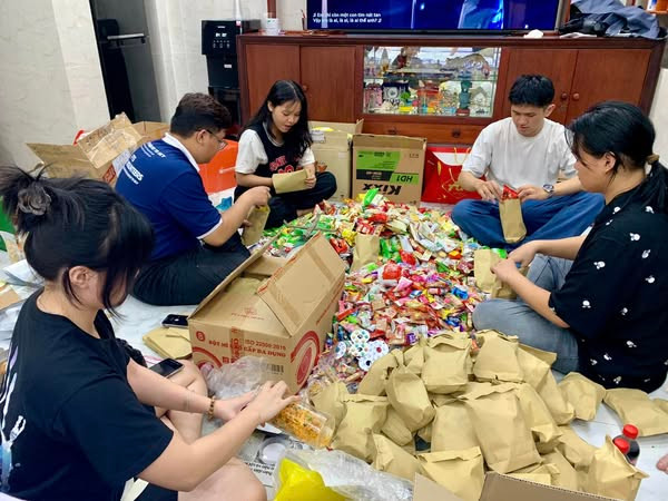 Nhóm phân loại bánh kẹo trước khi được gửi đến trẻ em khó khăn vùng biên giới.