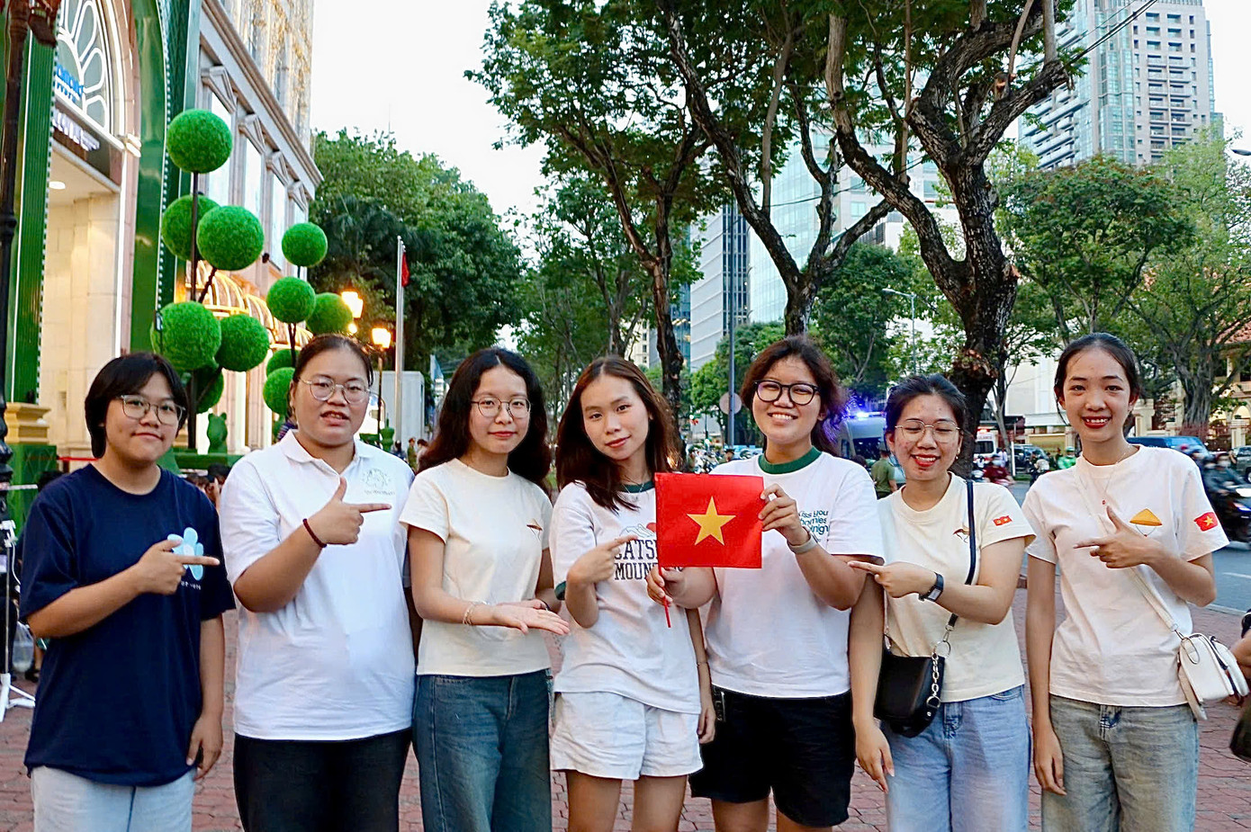 Yến Vy cùng các bạn đã có mặt tại khu vực Dinh Độc Lập, tay cầm lá cờ Tổ quốc, háo hức chờ đợi khoảnh khắc đội hình diễu binh xuất hiện. (Ảnh: Mỹ Đình)