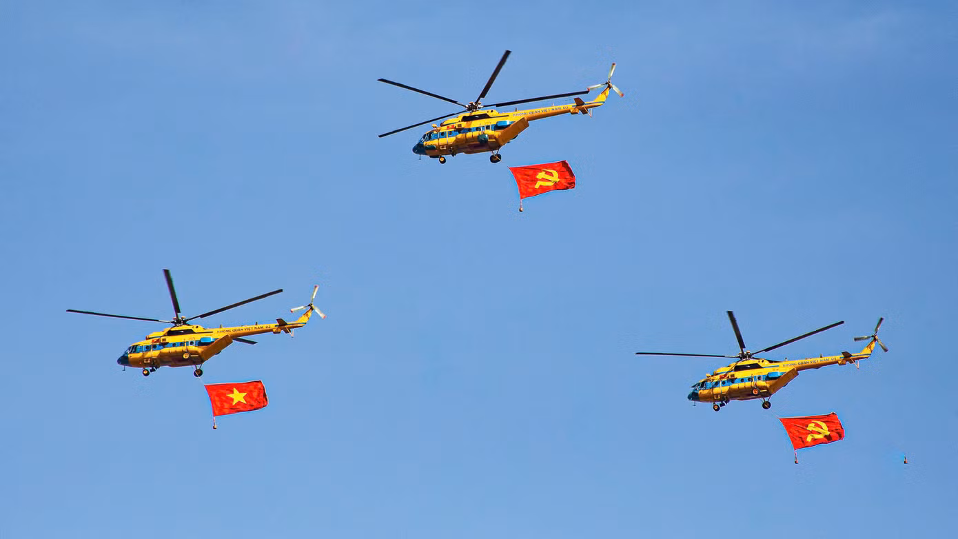 Những chiếc máy trực thăng mang cờ Tổ quốc và cờ Đảng. (Ảnh: Quang Vinh)
