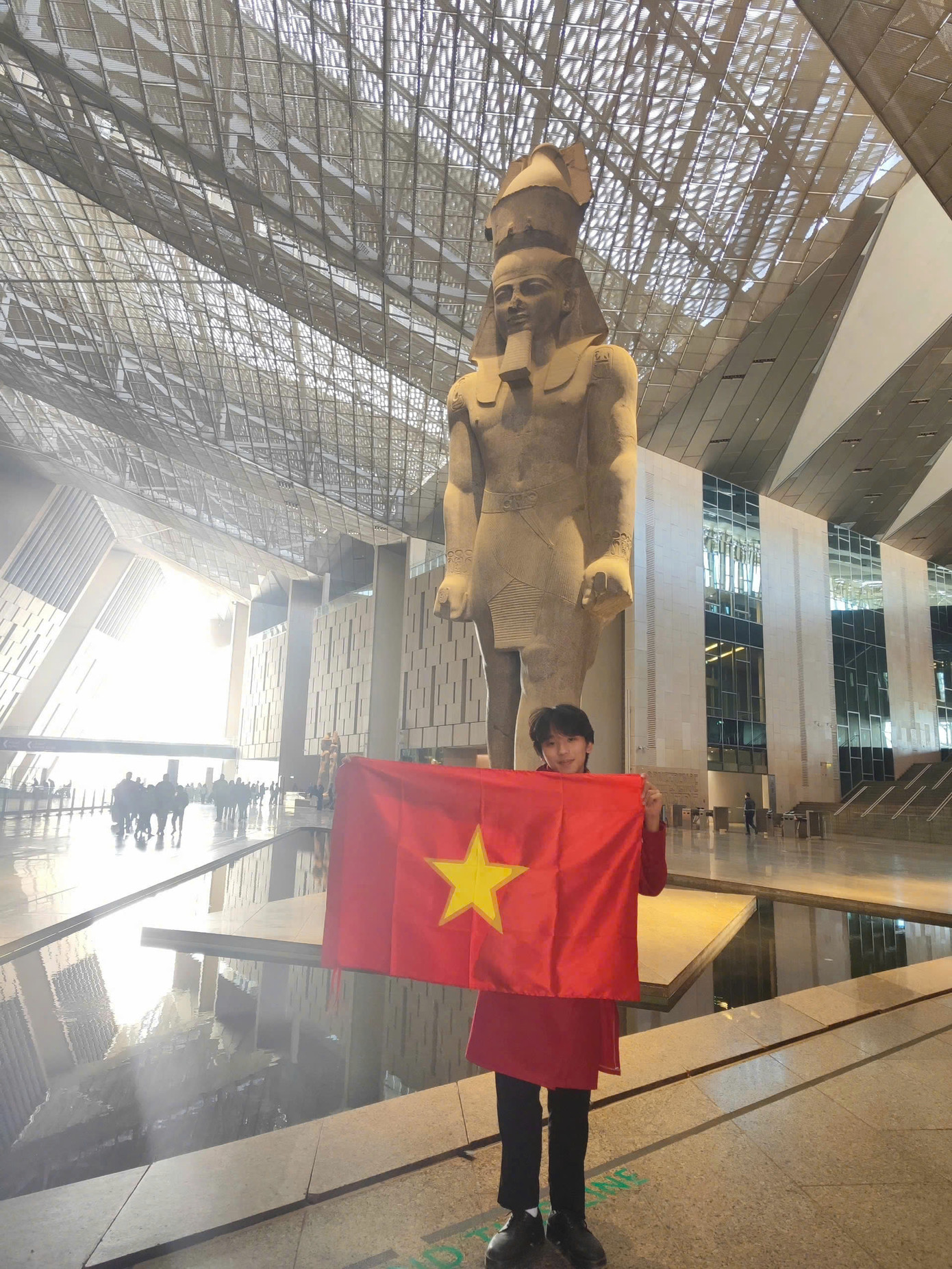 Huy Quang chụp ảnh kỉ niệm cùng lá cờ Tổ quốc và bộ áo dài truyền thống Việt Nam. Huy Quang chụp ảnh kỉ niệm cùng lá cờ Tổ quốc và bộ áo dài truyền thống Việt Nam.