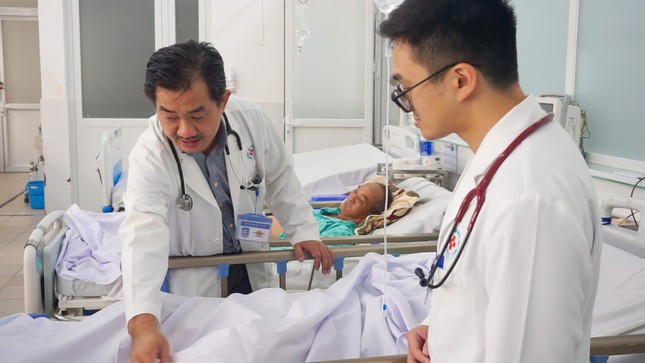 PGS. TS. BS Nguyễn Huy Thắng đang chăm sóc cho một bệnh nhân trẻ bị đột quỵ. (Ảnh: Tử Mạnh)