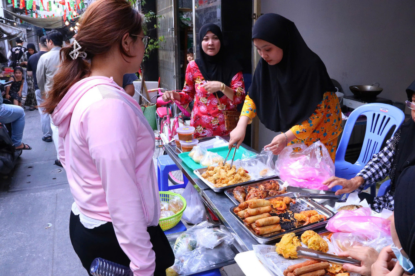 Một bạn trẻ đang mua đồ ăn tại một gian hàng bán các món đậm chất Hồi giáo.