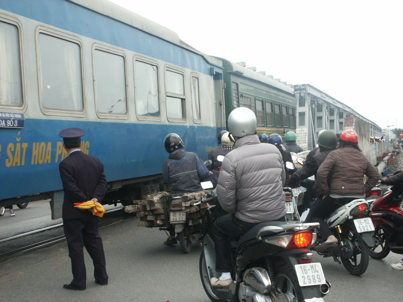 Tàu đang chạy nhưng người dân vẫn cố len sát vào chờ sớm được qua cầu.