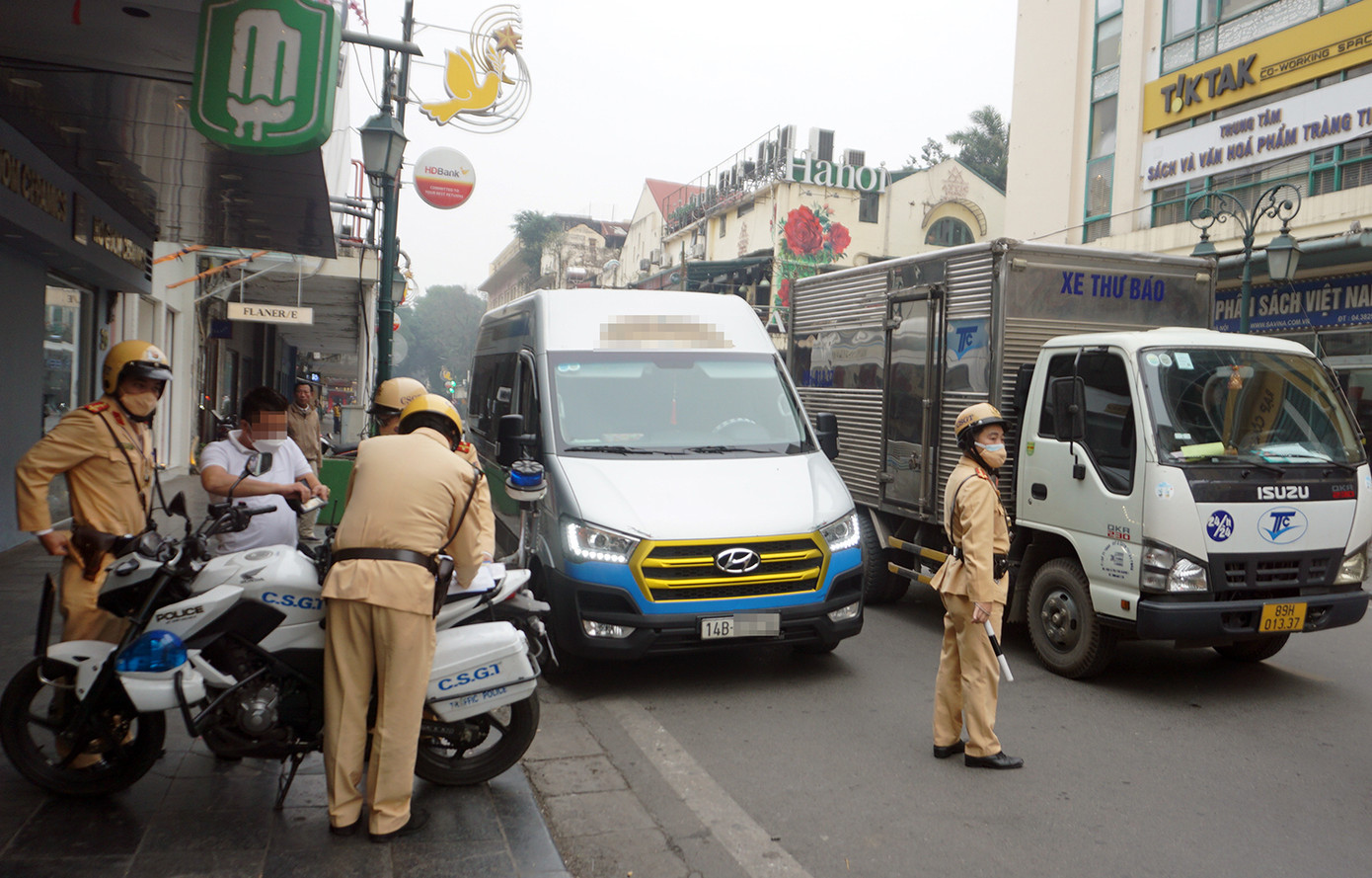 Một xe hợp đồng dừng đỗ trên tuyến phố Tràng Tiền gây cản trở giao thông.