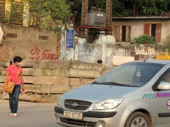 Tuyến đường 32 đang thi công, hiện chưa có nhà chờ xe buýt nào. Vì vậy người đứng đợi xe phải tự chủ động đối phó với thời tiết và bụi.