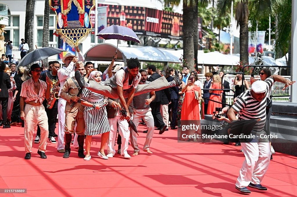 Nhóm nghệ sĩ gây chú ý với tiết mục biểu diễn náo loạn thảm đỏ ra mắt phim O Agente Secreto (L'Agent Secret/The Secret Agent) của đạo diễn Kleber Mendonça Filho. Phim lấy bối cảnh Brazil vào năm 1977, kể về chuyên gia công nghệ ngoài 40 tuổi Marcelo chạy trốn đến thành phố Recife vào đúng dịp diễn ra lễ hội hóa trang carnival. Ông hy vọng đoàn tụ với con trai, nhưng lại phát hiện ra thành phố này ẩn chứa nhiều nguy hiểm hơn anh tưởng. Ảnh: Getty Images.