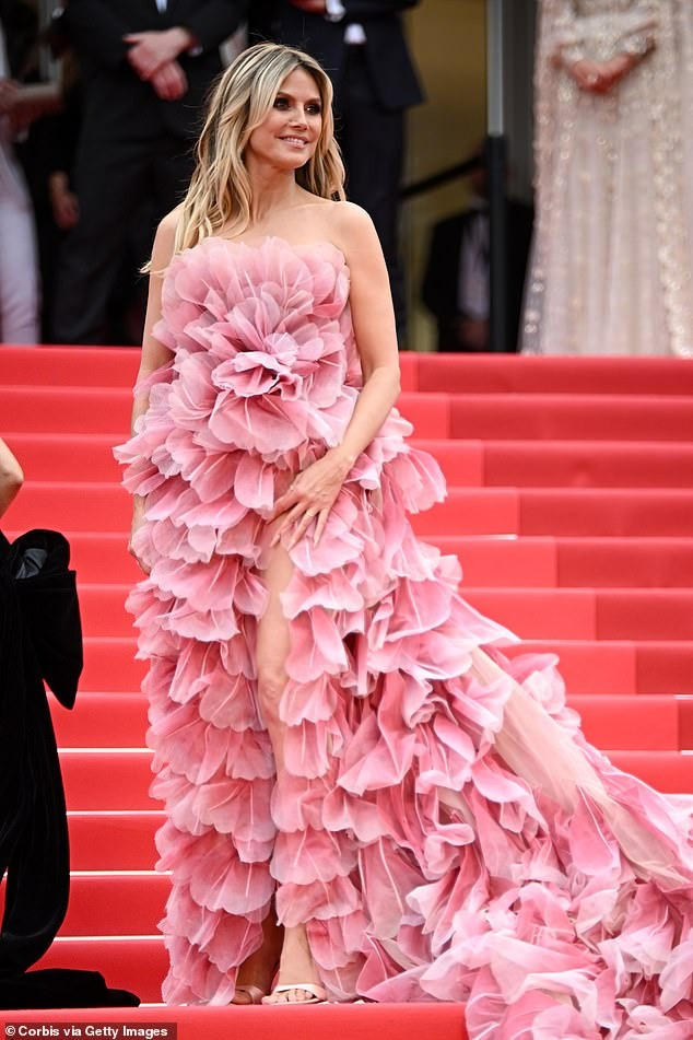 “Vì lý do lịch sự, việc khỏa thân bị cấm trên thảm đỏ, cũng như ở bất kỳ khu vực nào khác của liên hoan phim. Những bộ trang phục cồng kềnh, đặc biệt là những bộ có đuôi váy lớn, cản trở đi lại bình thường của khách mời và làm phức tạp việc sắp xếp chỗ ngồi trong rạp chiếu đều không được phép. Đội ngũ tiếp đón của liên hoan phim có nghĩa vụ cấm bất kỳ ai không tuân thủ các quy tắc này lên thảm đỏ”, quy định mới của Cannes nêu. Tuy nhiên, ban tổ chức không nói rõ độ lớn của trang phục như thế nào mới được gọi là cồng kềnh, bởi chiếc váy hồng của Heidi Klum có phần đuôi khá dài, phải cần đến sự hỗ trợ từ nhân viên, nhưng vẫn được chấp thuận cho lên thảm đỏ. Ảnh: Shutterstock/Getty Images. “Vì lý do lịch sự, việc khỏa thân bị cấm trên thảm đỏ, cũng như ở bất kỳ khu vực nào khác của liên hoan phim. Những bộ trang phục cồng kềnh, đặc biệt là những bộ có đuôi váy lớn, cản trở đi lại bình thường của khách mời và làm phức tạp việc sắp xếp chỗ ngồi trong rạp chiếu đều không được phép. Đội ngũ tiếp đón của liên hoan phim có nghĩa vụ cấm bất kỳ ai không tuân thủ các quy tắc này lên thảm đỏ”, quy định mới của Cannes nêu. Tuy nhiên, ban tổ chức không nói rõ độ lớn của trang phục như thế nào mới được gọi là cồng kềnh, bởi chiếc váy hồng của Heidi Klum có phần đuôi khá dài, phải cần đến sự hỗ trợ từ nhân viên, nhưng vẫn được chấp thuận cho lên thảm đỏ. Ảnh: Shutterstock/Getty Images.