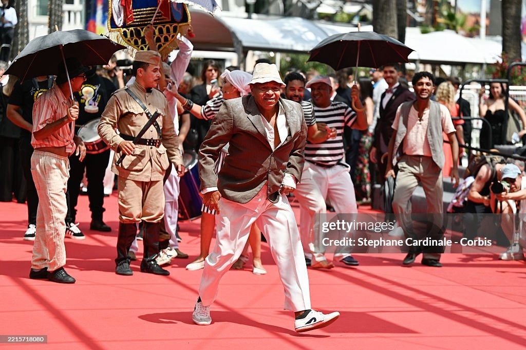 Nhóm nghệ sĩ gây chú ý với tiết mục biểu diễn náo loạn thảm đỏ ra mắt phim O Agente Secreto (L'Agent Secret/The Secret Agent) của đạo diễn Kleber Mendonça Filho. Phim lấy bối cảnh Brazil vào năm 1977, kể về chuyên gia công nghệ ngoài 40 tuổi Marcelo chạy trốn đến thành phố Recife vào đúng dịp diễn ra lễ hội hóa trang carnival. Ông hy vọng đoàn tụ với con trai, nhưng lại phát hiện ra thành phố này ẩn chứa nhiều nguy hiểm hơn anh tưởng. Ảnh: Getty Images.