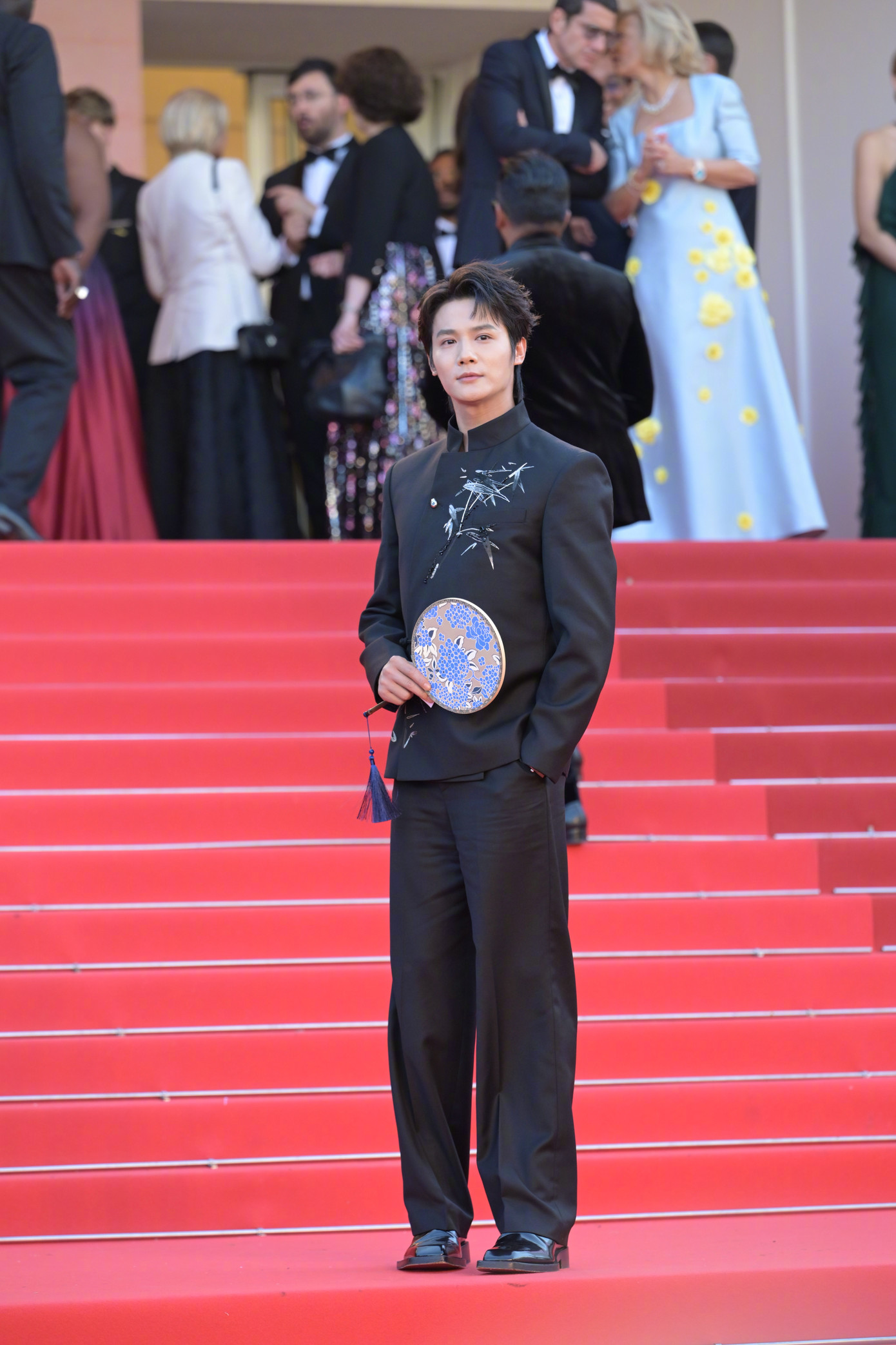Nam diễn viên Trịnh Nghiệp Thành mặc trang phục đậm nét văn hóa Trung Quốc với họa tiết lá tre trên áo và quạt tròn. Tuy vậy, ngôi sao sinh năm 1993 mờ nhạt trên thảm đỏ Cannes. Ảnh: Weibo.