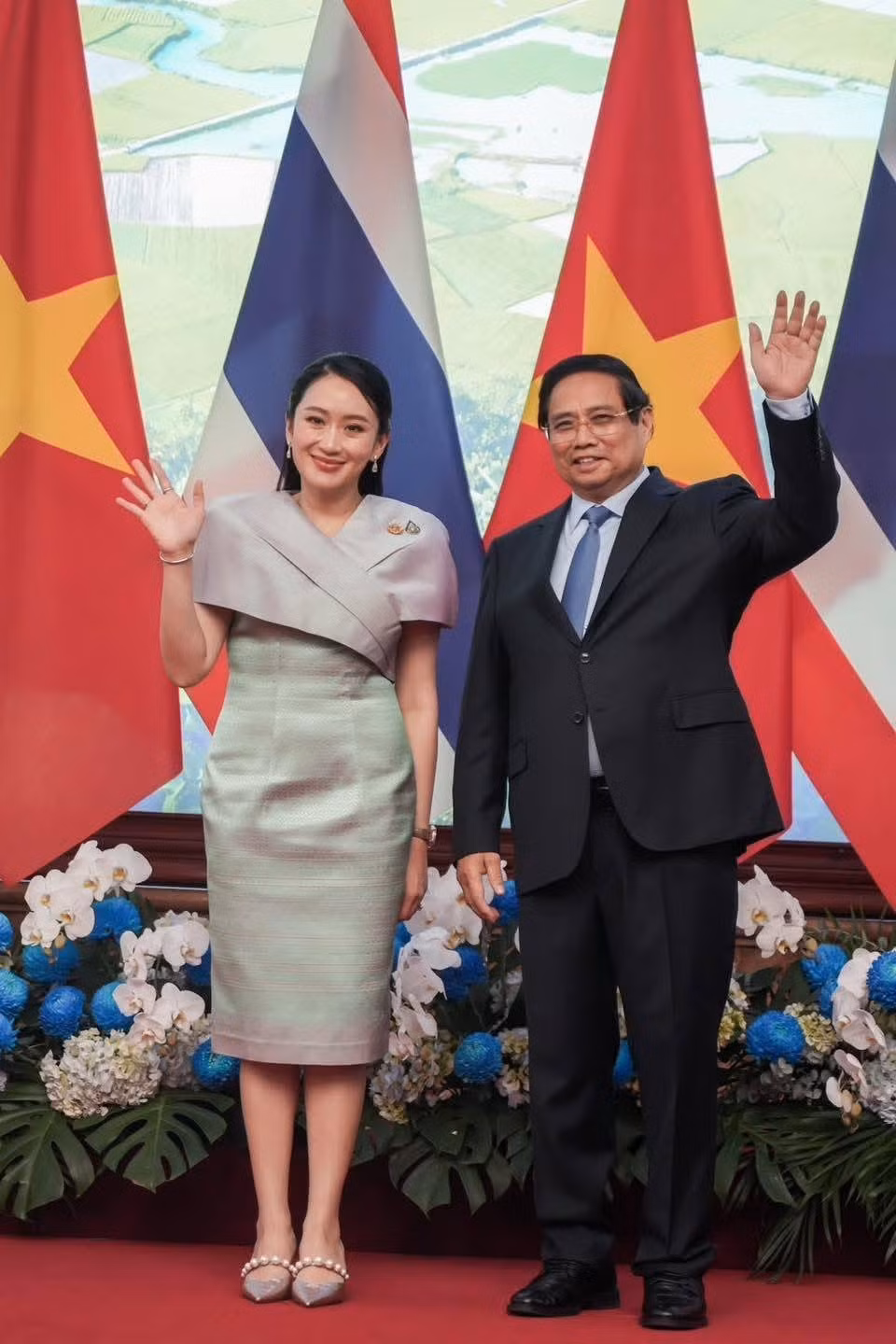 Trong buổi tham quan triển lãm các sản phẩm thủ công mỹ nghệ đặc sắc của Việt Nam với Thủ tướng Phạm Minh Chính vào chiều tối 15/5, Thủ tướng Paetongtarn Shinawatra đổi sang váy liền thân, với điểm nhấn là phần cổ và tay áo. Màu sắc tiếp tục là điểm thu hút của bộ cánh. Màu xanh lá và tím nhạt giúp chiếc váy không quá nổi bật, nhưng cũng không bị nhạt nhòa. Thủ tướng Thái Lan thay đổi từ phụ kiện vàng sang bạc để phù hợp trang phục. Đôi giày bạc có quai ngọc tăng thêm phần thời thượng. Ảnh: NBT Connext.