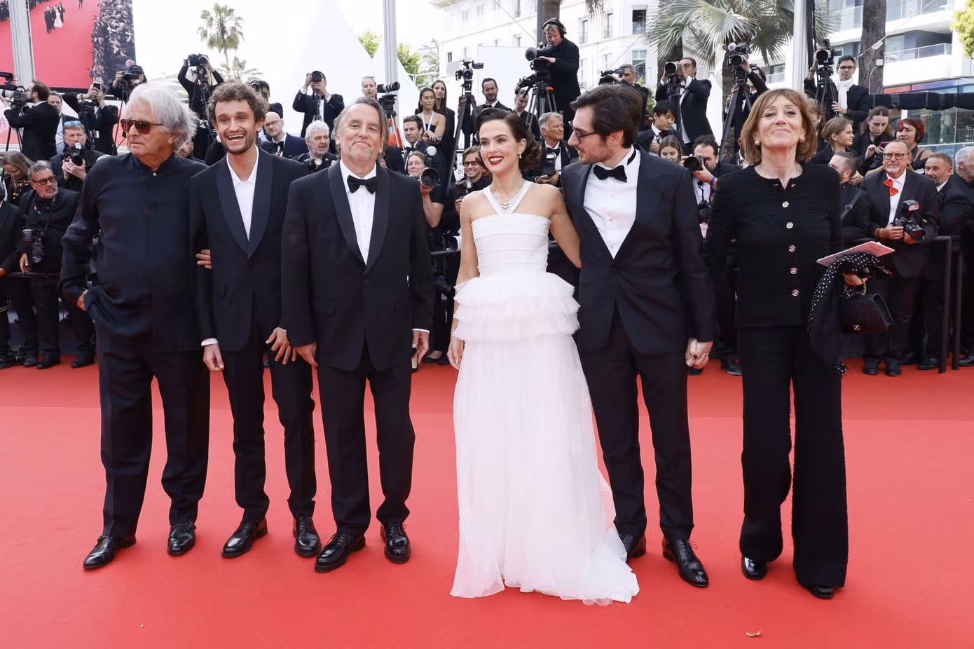 Ngày thứ năm của Liên hoan phim Cannes 2025 diễn ra buổi công chiếu bộ phim Pháp Nouvelle Vague (New Wave) do Richard Linklater (đứng thứ ba từ trái sang) đạo diễn. Ông cùng các diễn viên Laurent Petin, Aubry Dullin, Zoey Deutch, Guillaume Marbeck và nhà sản xuất phim Michele Halberstadt (từ trái sang phải) ra mắt giới truyền thông trên thảm đỏ. Họ mang đến Cannes tác phẩm tiểu sử về đạo diễn, biên kịch huyền thoại Jean-Luc Godard (1930-2022), Ảnh: Invision.