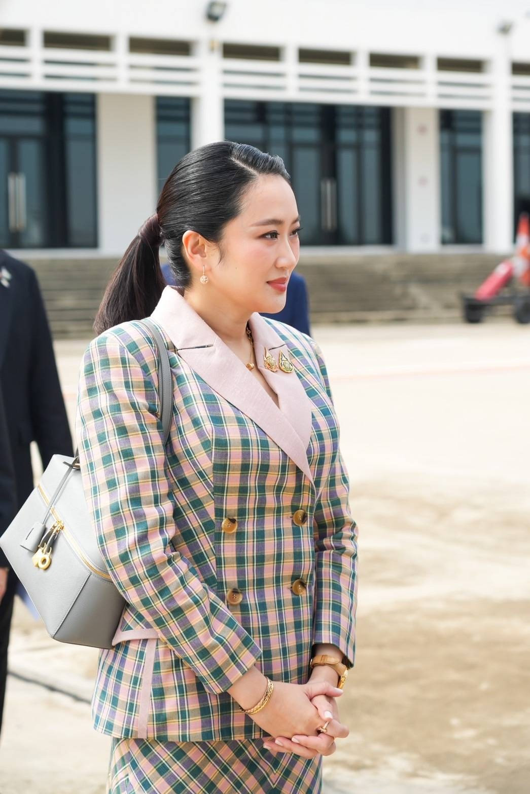 Nữ thủ tướng hoàn thiện vẻ ngoài đẳng cấp bằng những món trang sức vàng không quá cầu kỳ nhưng đủ rực rỡ. Nếu trang phục là đại diện cho xu hướng hiện đại, phụ kiện phản ánh yếu tố truyền thống trong phong cách của Thủ tướng Shinawatra. Rõ nhất là hai chiếc ghim cài áo. Chúng được nữ thủ tướng sử dụng xuyên suốt chuyến thăm Việt Nam. Ảnh: NBT Connext.