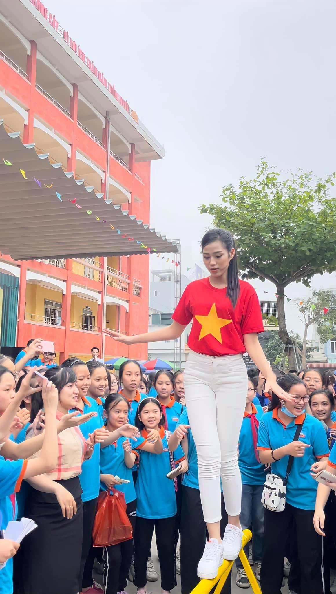 Người đẹp diện áo cờ đỏ sao vàng và không ngần ngại tham gia các thử thách cùng các em học sinh.