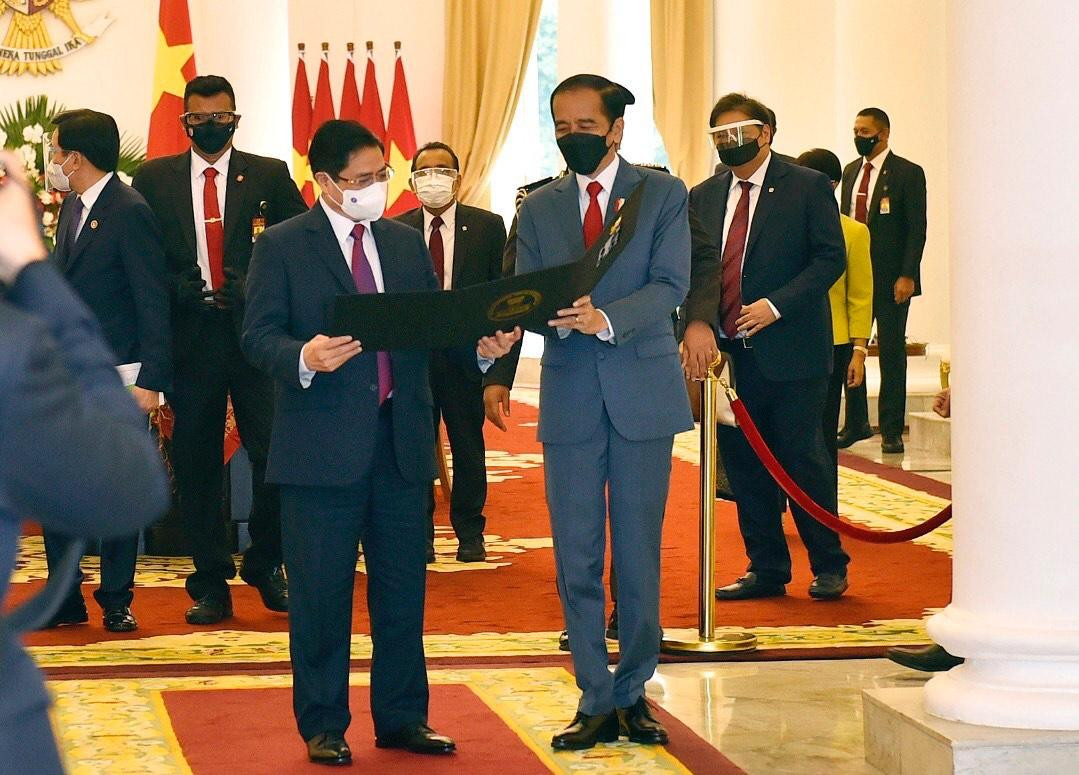 Tổng thống Indonesia Joko Widodo tặng quà cho Thủ tướng Phạm Minh Chính. (Ảnh: Đoàn Bắc)