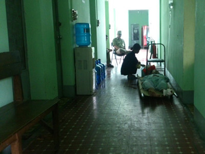 Tuấn (nằm cáng) đã bị đưa về Công an quận Bình Thạnh lấy lời khai và bị tạm giữ