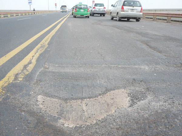 Mặt cầu Thăng Long lún sâu và trơ cả tấm bản thép bên dưới. Ảnh: Trọng Đảng