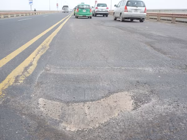 Mặt cầu Thăng Long lún sâu và trơ cả tấm bản thép bên dưới. Ảnh: Trọng Đảng