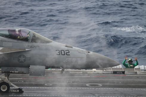 Một nhân viên điều khiển đang chuẩn bị cho chiếc F/A-18 Super Hornet cất cánh. USS George Washington có 4 động cơ đẩy, cho phép hai phi cơ cất cánh cùng lúc