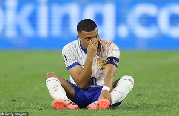 Mbappe ôm mũi quay lại ngồi trên sân để trận đấu chưa tiếp tục được. Ảnh: Getty.