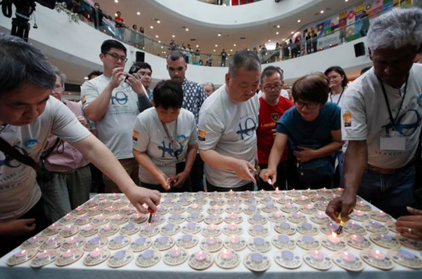 Người thân của các hành khách đã đi trên chuyến bay MH370 thắp nến trong lễ tưởng niệm 10 năm, diễn ra ở Subang Jaya (gần Kuala Lumpur, Malaysia). Ảnh: FL Wong/ AP.