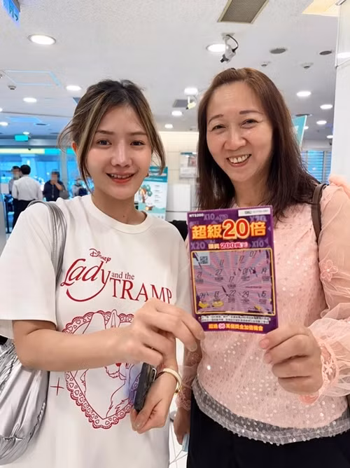 Nữ du khách may mắn (bên trái) trúng xổ số cào. Ảnh: Apinya Pongpotjaman.
